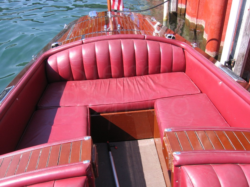 A boat that is sitting on a red bench
